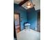 Bedroom featuring a fan and a chair with a stack of clothes in the corner with a blue wall at 4163 Otterbein Ave, Indianapolis, IN 46227