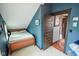 Cozy bedroom featuring a bed and a doorway in the corner with blue wall at 4163 Otterbein Ave, Indianapolis, IN 46227