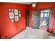 Bedroom boasting a red wall, a framed art collection, and a doorway with wooden trim at 4163 Otterbein Ave, Indianapolis, IN 46227
