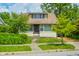 A cozy two-story home featuring classic architecture and inviting curb appeal with mature trees and landscaping at 4163 Otterbein Ave, Indianapolis, IN 46227
