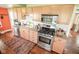 Well-lit kitchen featuring stainless steel appliances, plentiful cabinetry, and hardwood floors at 4163 Otterbein Ave, Indianapolis, IN 46227