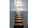 Staircase featuring wood steps and black carpet treads leading upwards at 4163 Otterbein Ave, Indianapolis, IN 46227