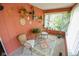 Bright sunroom with wicker furniture, plants, and a vibrant rug, creating a cozy and inviting space at 4163 Otterbein Ave, Indianapolis, IN 46227