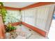 Bright sunroom features large windows with vertical blinds, charming decor, and lots of natural light at 4163 Otterbein Ave, Indianapolis, IN 46227