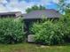 Backyard with overgrown bushes, air conditioner, and screened door at 4336 Abby Creek Ln, Indianapolis, IN 46205