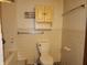 Bathroom with a toilet, tiled walls, and overhead cabinets at 4336 Abby Creek Ln, Indianapolis, IN 46205