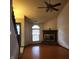 Spacious living room featuring a brick fireplace, hardwood floors, a ceiling fan, and a large window at 4336 Abby Creek Ln, Indianapolis, IN 46205