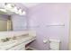 A clean bathroom is adorned with a purple color scheme, and marble-looking countertop at 4504 Harvard Dr, Anderson, IN 46013