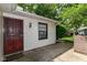 Inviting front entrance with a secured red door, white siding, and a convenient outdoor light fixture at 4504 Harvard Dr, Anderson, IN 46013