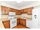 Bright kitchen with white appliances, wooden cabinets, and a tile backsplash at 4504 Harvard Dr, Anderson, IN 46013