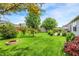 Well maintained backyard with fire pit, lush lawn, mature trees, and decorative bushes at 482 Sycamore St, Brownsburg, IN 46112