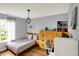 Comfortable bedroom with twin bed, wood floors, pendant light, and a desk workspace with bright natural light at 482 Sycamore St, Brownsburg, IN 46112
