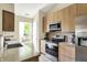 Well-lit kitchen featuring stainless steel appliances, granite countertops, and wood cabinets at 482 Sycamore St, Brownsburg, IN 46112