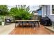 Cozy backyard with a wooden deck, a grill, a patio table, and lots of greenery at 5015 N Park Ave, Indianapolis, IN 46205