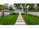 Grassy backyard features a walkway leading to the garage at 5015 N Park Ave, Indianapolis, IN 46205