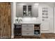 Modern bar area with gray cabinets, wine fridge, and wood-look flooring at 5015 N Park Ave, Indianapolis, IN 46205