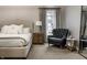 Comfortable bedroom with a sitting chair, side table, and decorative curtains creates a cozy space at 5015 N Park Ave, Indianapolis, IN 46205