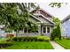 Attractive two-story home with a well-manicured lawn, mature landscaping, and covered porch at 5015 N Park Ave, Indianapolis, IN 46205