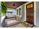 Inviting front porch with rocking chairs, swing, wood ceiling, and decorative rugs at 5015 N Park Ave, Indianapolis, IN 46205