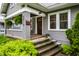 Covered front porch with traditional columns and lush landscaping surrounding entrance at 5015 N Park Ave, Indianapolis, IN 46205