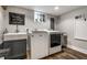 Bright laundry room with modern washer, dryer, utility sink and hardwood floors at 5015 N Park Ave, Indianapolis, IN 46205