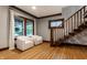 Bright room featuring hardwood floors, two white chairs, dark trim, and stairs at 5015 N Park Ave, Indianapolis, IN 46205