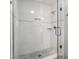 Modern shower showcasing white tiles, glass door, and convenient shelving at 5015 N Park Ave, Indianapolis, IN 46205