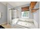 Bathroom with a bathtub, tiled wall, and a shower with glass door at 5041 Millwright Ct, Indianapolis, IN 46254