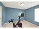 Bright blue exercise room with a modern stationary bike on neutral carpeting, perfect for a home gym at 5041 Millwright Ct, Indianapolis, IN 46254
