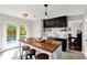 Stylish kitchen featuring a wooden island, dark cabinets, and stainless steel appliances with access to the backyard at 5041 Millwright Ct, Indianapolis, IN 46254
