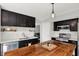 Open kitchen with dark cabinetry, stainless steel appliances, white backsplash, and large wood-top island at 5041 Millwright Ct, Indianapolis, IN 46254