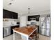 Spacious kitchen with a wooden island, stainless steel appliances, and dark cabinets, ideal for Gathering gatherings at 5041 Millwright Ct, Indianapolis, IN 46254
