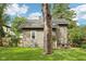 Backyard featuring a stone fireplace, established trees, and lush green lawn, creating a serene outdoor space at 5117 N Park Ave, Indianapolis, IN 46205