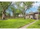 Beautiful fenced backyard with mature trees and lush green grass, perfect for outdoor activities and relaxation at 5117 N Park Ave, Indianapolis, IN 46205