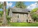 Exterior of home in backyard featuring a stone fireplace and lush landscaping with a large tree at 5117 N Park Ave, Indianapolis, IN 46205