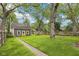 Spacious backyard featuring a lush green lawn with mature trees and a charming gray outbuilding at 5117 N Park Ave, Indianapolis, IN 46205