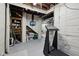 Basement area showing white painted brick walls, a small TV, a treadmill, and visible ceiling beams and piping at 5117 N Park Ave, Indianapolis, IN 46205