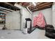 Unfinished basement area showcasing a treadmill, painted brick walls, and a view of the ceiling beams and piping at 5117 N Park Ave, Indianapolis, IN 46205