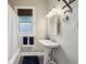 Bathroom with a pedestal sink, window, and tiled flooring near the shower and bathtub at 5117 N Park Ave, Indianapolis, IN 46205