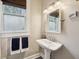 Bathroom features a pedestal sink, stylish mirror, and a well-lit space near the shower and tub at 5117 N Park Ave, Indianapolis, IN 46205