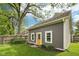 Charming home featuring gray siding, a bright yellow door, and manicured landscaping at 5117 N Park Ave, Indianapolis, IN 46205