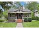 Charming bungalow with brick accents, a cozy front porch, and well-manicured landscaping at 5117 N Park Ave, Indianapolis, IN 46205