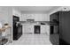 Updated kitchen features modern appliances, white cabinetry, and white tile floors at 5353 Chipwood Ln, Indianapolis, IN 46226