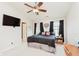 Bright bedroom with a ceiling fan, dark curtains, and a mounted TV for a modern feel at 5913 Monticello Square Ln, Indianapolis, IN 46234