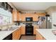 Well-lit kitchen with stainless steel appliances, wooden cabinets, and an island with white countertop at 5913 Monticello Square Ln, Indianapolis, IN 46234