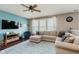 Comfortable living room with a large sectional couch, ceiling fan, hardwood floors, and a wall-mounted TV at 5913 Monticello Square Ln, Indianapolis, IN 46234