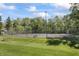 Community tennis court with well-maintained fencing, seating, and surrounding green trees at 601 Conner Creek Dr, Fishers, IN 46038