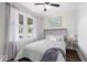 Comfortable bedroom featuring a plush bed, ceiling fan, and street view from the window at 606 E County Line Rd, Indianapolis, IN 46227
