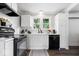 Updated kitchen boasts a modern backsplash, black appliances, and abundant natural light at 606 E County Line Rd, Indianapolis, IN 46227