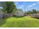 Large, green backyard featuring a patio, lush grass, and a wooden fence at 6102 Primrose Ave, Indianapolis, IN 46220